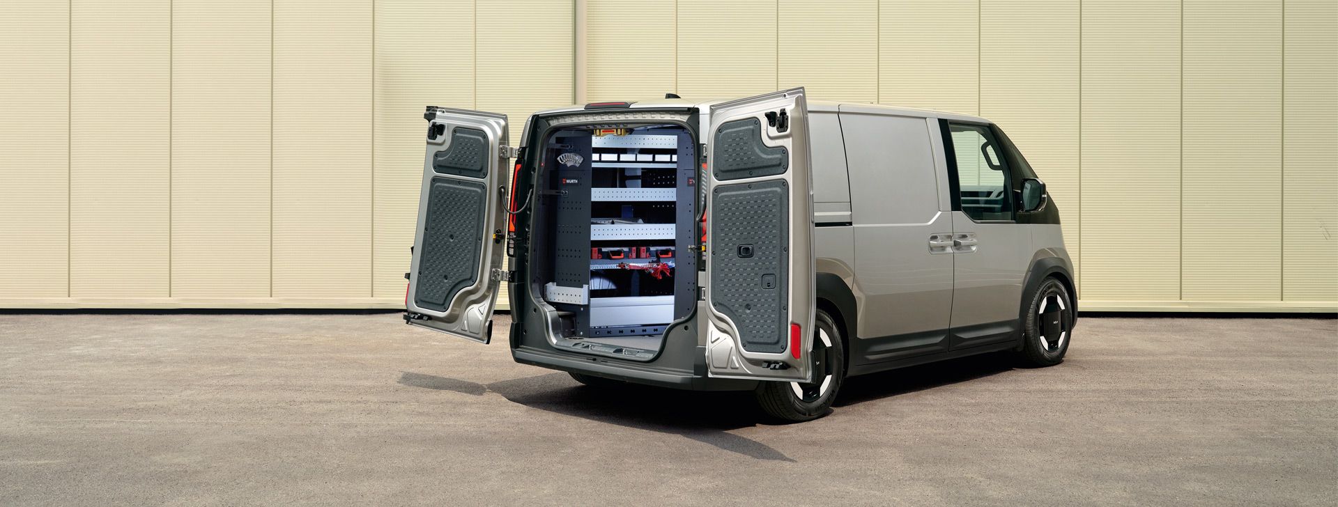 Der Kia PV5 Cargo in Heckansicht mit geöffneten Türen, eingebaute Würth-Regalsysteme sind sichtbar